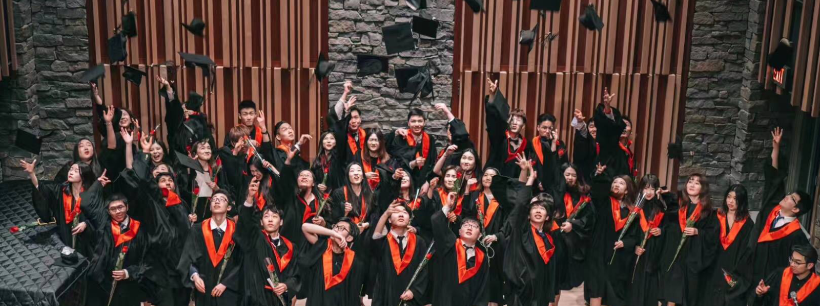 Columbia Academy students tossing graduation caps into the air